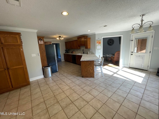 kitchen with dishwasher, ornamental molding, sink, and stainless steel refrigerator