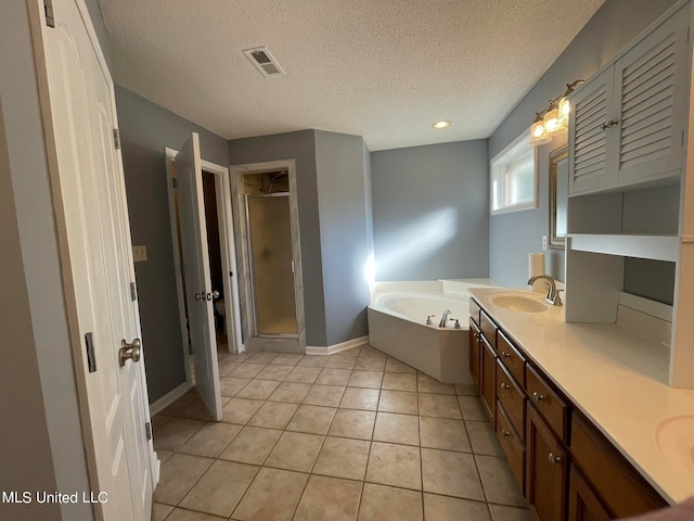 bathroom featuring tile patterned floors, shower with separate bathtub, a textured ceiling, and vanity