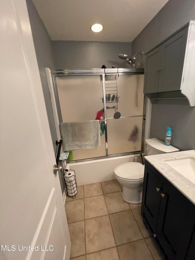 full bathroom featuring enclosed tub / shower combo, toilet, tile patterned floors, and vanity