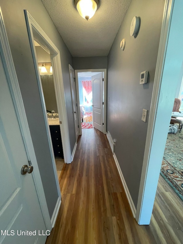 hall featuring dark hardwood / wood-style flooring and a textured ceiling