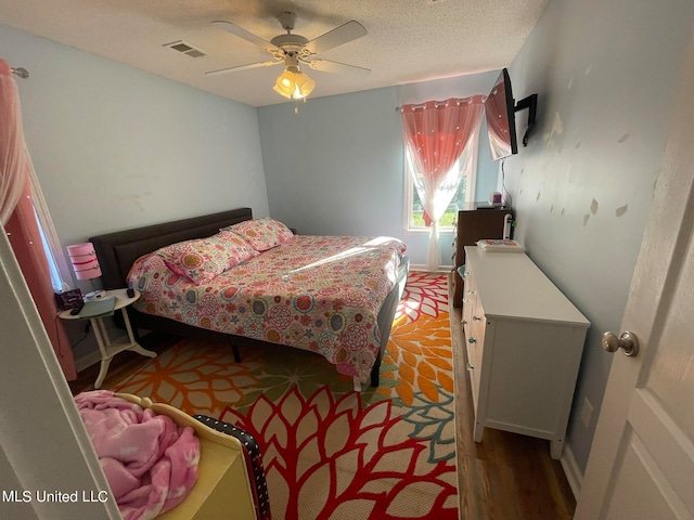 bedroom with ceiling fan, a textured ceiling, and light wood-type flooring