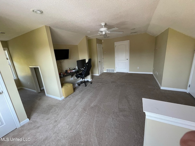 unfurnished office featuring lofted ceiling, ceiling fan, a textured ceiling, and carpet