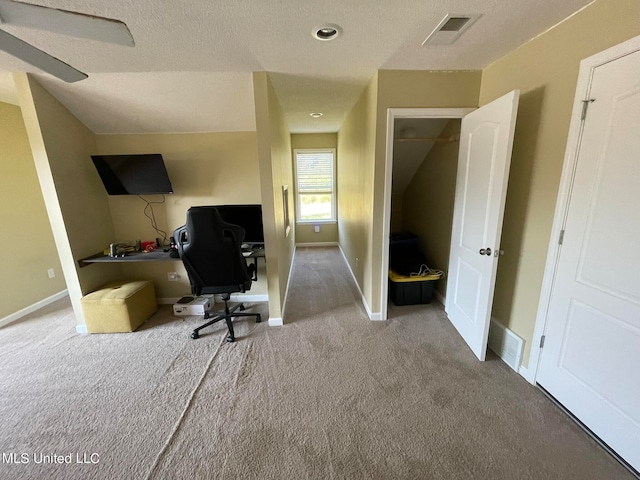 office with carpet floors and a textured ceiling