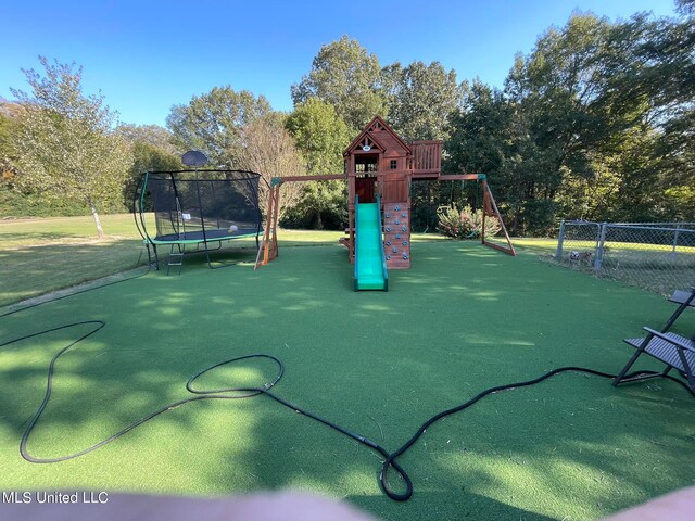 view of playground featuring a trampoline and a lawn