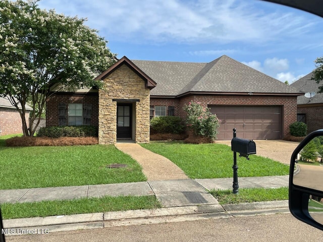 409 Sand Stone Pl, Brandon, MS 39042 - view of front of house with roof with shingles, an attached garage, a front yard, stone siding, and brick siding