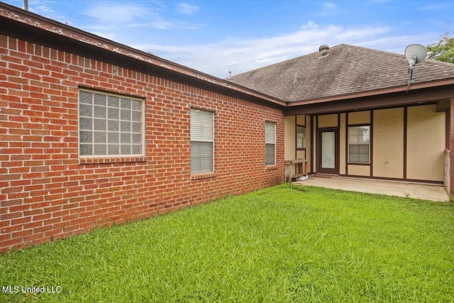 409 Sand Stone Pl, Brandon, MS 39042 - rear view of property featuring a yard, brick siding, a shingled roof, and a patio