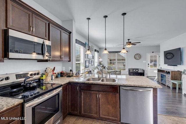 16904 Desmare St, Gulfport, MS 39503 - kitchen with appliances with stainless steel finishes, open floor plan, a peninsula, ceiling fan, and dark brown cabinetry