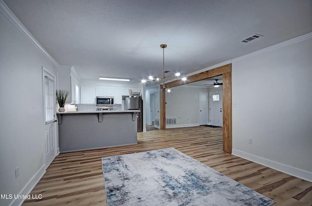 311 Danbar St, Brandon, MS 39042 - kitchen featuring stainless steel appliances, ornamental molding, white cabinets, a peninsula, and light wood-style flooring