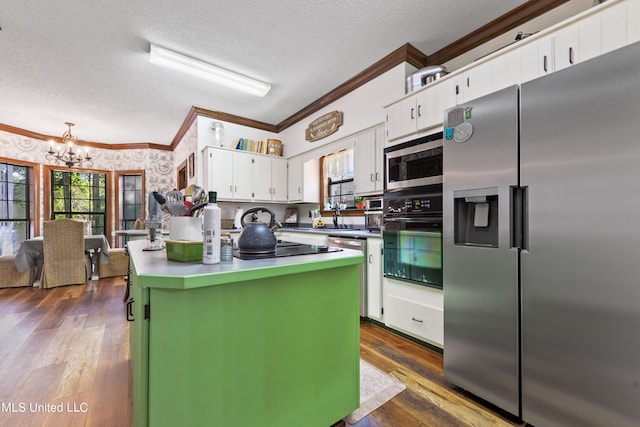 kitchen with dark hardwood / wood-style floors, a center island, white cabinets, appliances with stainless steel finishes, and a textured ceiling