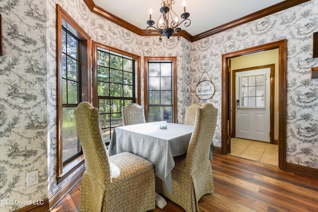 dining space with a notable chandelier, hardwood / wood-style flooring, and ornamental molding