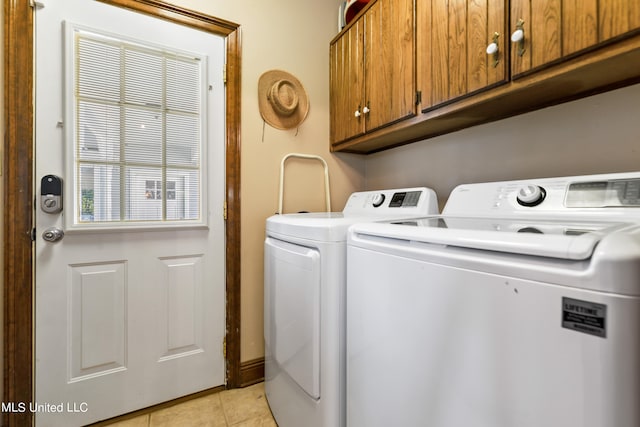 laundry room featuring independent washer and dryer, light tile patterned flooring, and cabinets