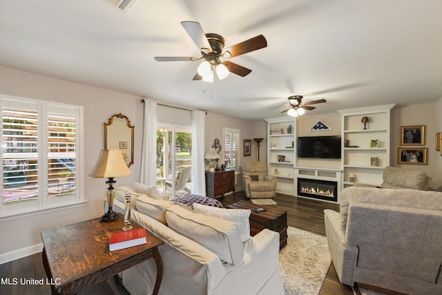 living room with ceiling fan and dark hardwood / wood-style flooring