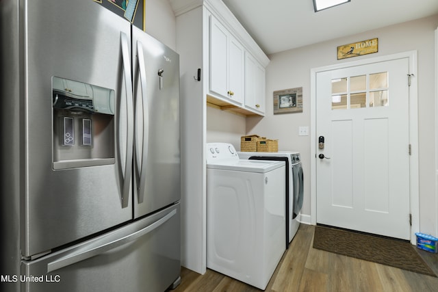 washroom with washer and clothes dryer, hardwood / wood-style flooring, and cabinets