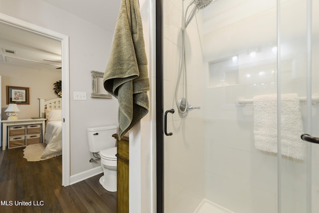 bathroom with toilet, hardwood / wood-style floors, and walk in shower