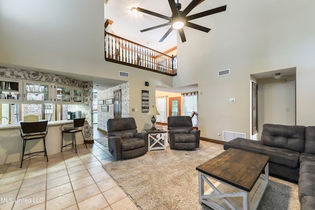 living room featuring a high ceiling, light tile patterned flooring, and ceiling fan