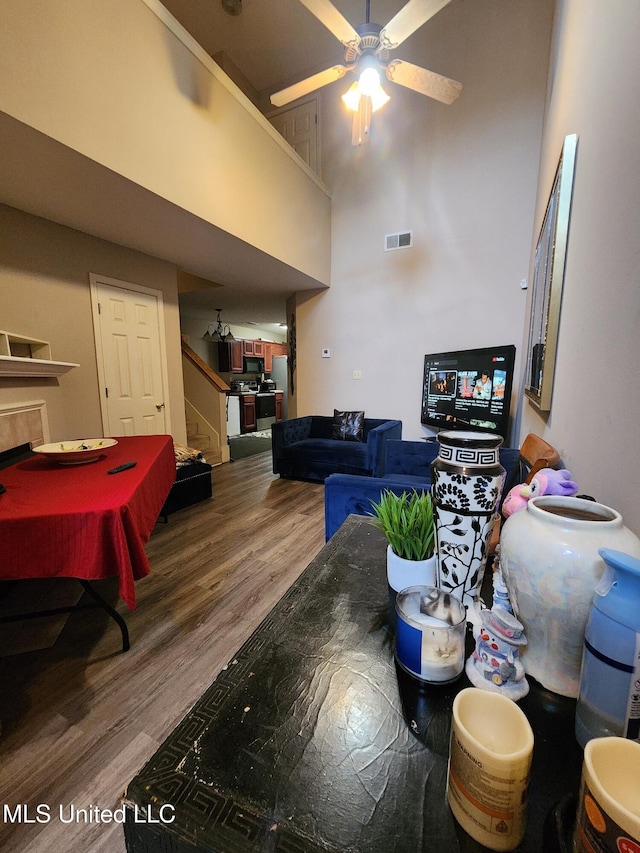 7295 Madelyn Cv, Horn Lake, MS 38637 - living area with stairway, wood finished floors, ceiling fan, and a towering ceiling