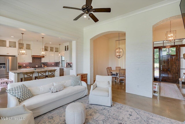 110 Crossview Pl, Brandon, MS 39047 - living room with a chandelier, arched walkways, finished concrete flooring, crown molding, and ceiling fan