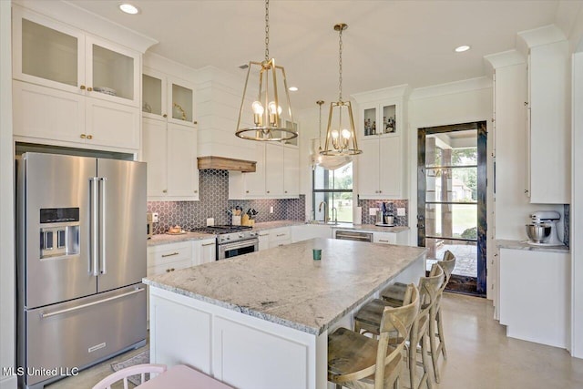110 Crossview Pl, Brandon, MS 39047 - kitchen with premium appliances, a chandelier, tasteful backsplash, a kitchen island, and ornamental molding