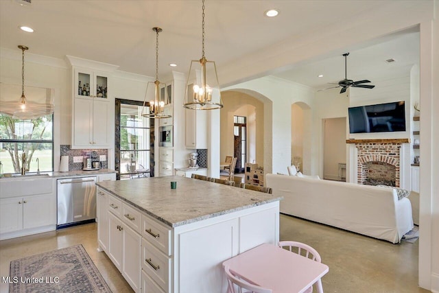 110 Crossview Pl, Brandon, MS 39047 - kitchen featuring stainless steel dishwasher, arched walkways, a center island, white cabinetry, and ornamental molding