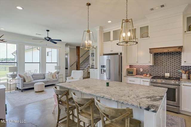 110 Crossview Pl, Brandon, MS 39047 - kitchen featuring appliances with stainless steel finishes, a center island, decorative backsplash, white cabinetry, and recessed lighting