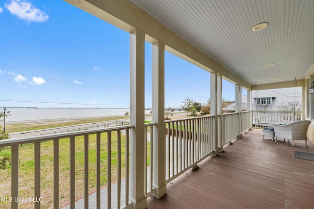 wooden terrace featuring a water view and covered porch