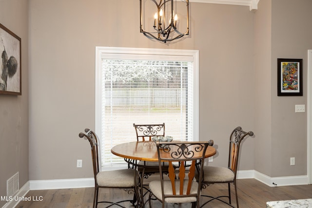 dining area featuring wood-type flooring and a chandelier