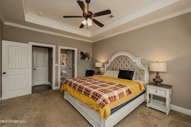 carpeted bedroom featuring crown molding, a raised ceiling, ceiling fan, and ensuite bathroom