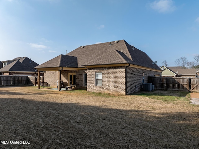 rear view of house with a yard, central AC unit, and a patio