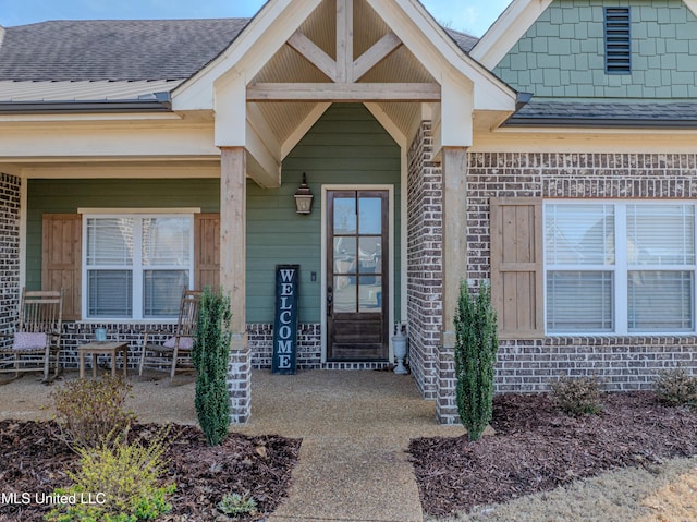 view of exterior entry featuring covered porch