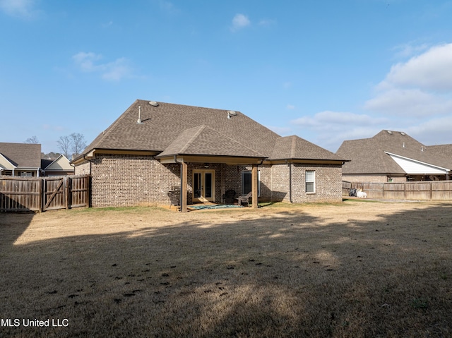 rear view of house featuring a lawn and a patio area