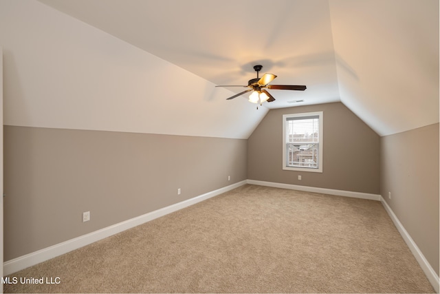 bonus room with vaulted ceiling, light colored carpet, and ceiling fan