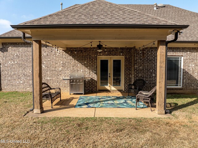 rear view of house with french doors, a yard, ceiling fan, and a patio area