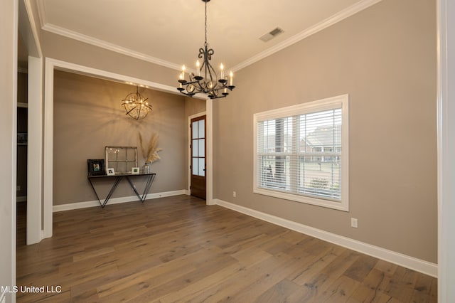 unfurnished room featuring hardwood / wood-style flooring, crown molding, and a notable chandelier