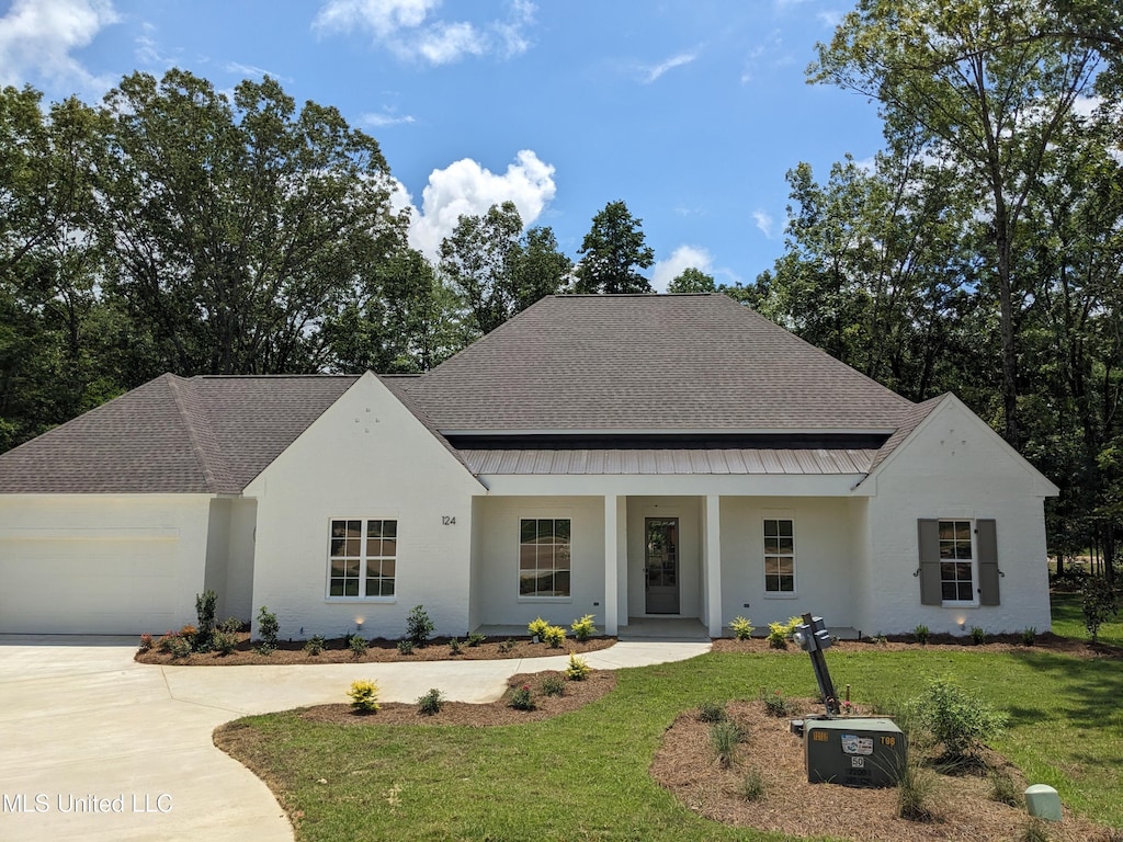 124 Camden Rdg, Madison, MS 39110 - view of front facade with a standing seam roof, a garage, a front yard, and a porch