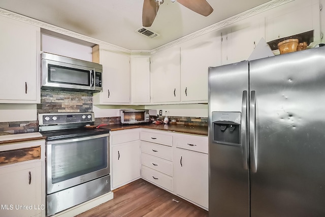 kitchen with appliances with stainless steel finishes, ceiling fan, white cabinets, decorative backsplash, and dark hardwood / wood-style floors