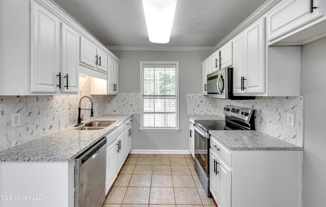 783 Whippoorwill Dr, Brandon, MS 39047 - kitchen with appliances with stainless steel finishes, white cabinetry, light tile patterned floors, backsplash, and ornamental molding