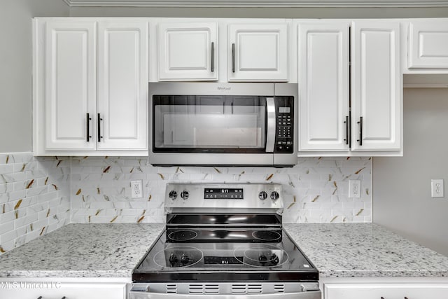 783 Whippoorwill Dr, Brandon, MS 39047 - kitchen with appliances with stainless steel finishes, white cabinets, backsplash, and light stone counters
