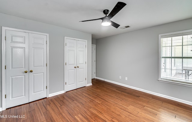 783 Whippoorwill Dr, Brandon, MS 39047 - unfurnished bedroom with multiple closets, wood finished floors, and a ceiling fan