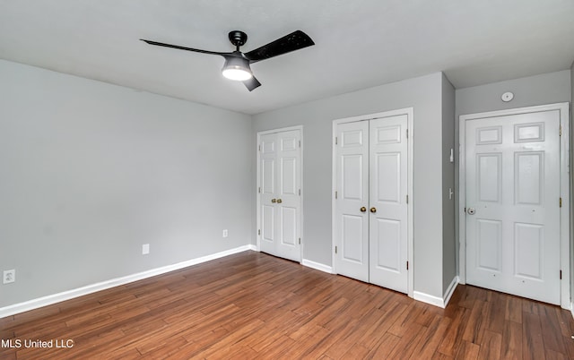 783 Whippoorwill Dr, Brandon, MS 39047 - unfurnished bedroom with wood finished floors, a ceiling fan, and two closets