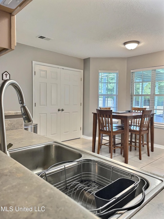 8617 Pinoak Ln, Ocean Springs, MS 39564 - kitchen featuring healthy amount of natural light, light tile patterned flooring, and a textured ceiling