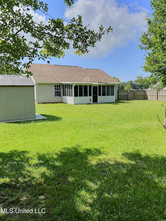 8617 Pinoak Ln, Ocean Springs, MS 39564 - back of house featuring a sunroom, a shed, a fenced backyard, and roof with shingles