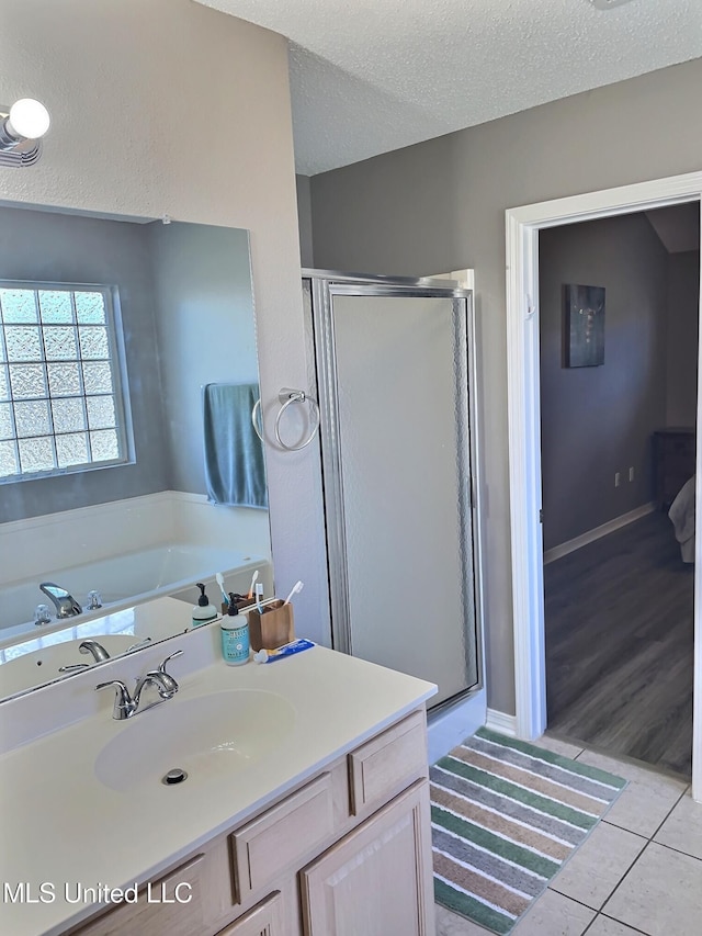 8617 Pinoak Ln, Ocean Springs, MS 39564 - full bath featuring a stall shower, tile patterned flooring, vanity, a textured ceiling, and a garden tub