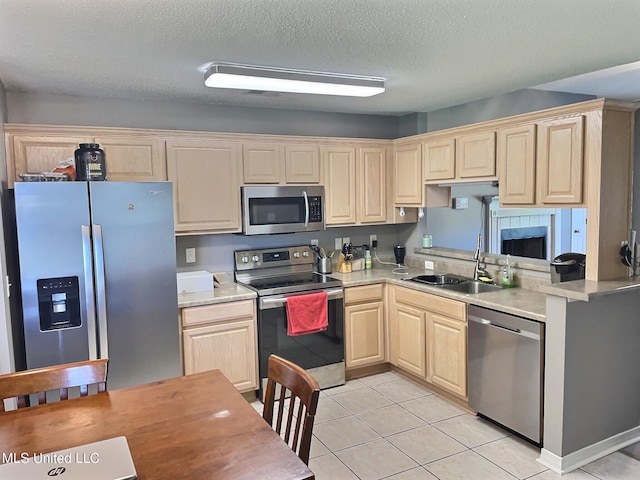 8617 Pinoak Ln, Ocean Springs, MS 39564 - kitchen with appliances with stainless steel finishes, light brown cabinetry, light countertops, light tile patterned flooring, and a textured ceiling