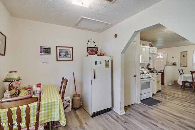 869 B Parks Rd, Pickens, MS 39146 - kitchen with white appliances, a textured ceiling, light wood-style floors, white cabinetry, and light countertops