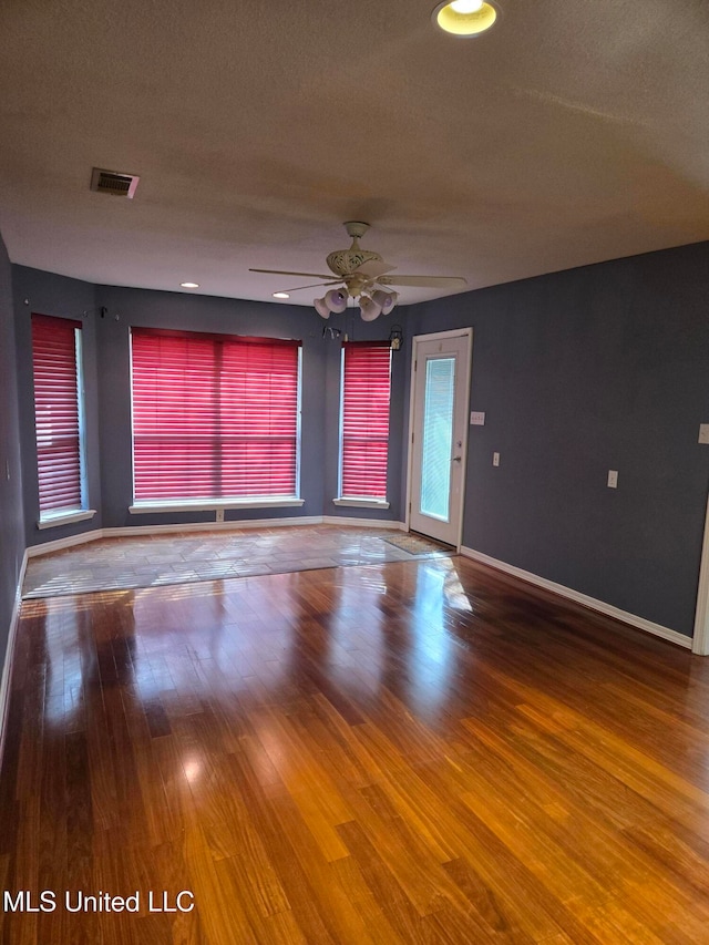 spare room featuring ceiling fan, hardwood / wood-style floors, and a textured ceiling