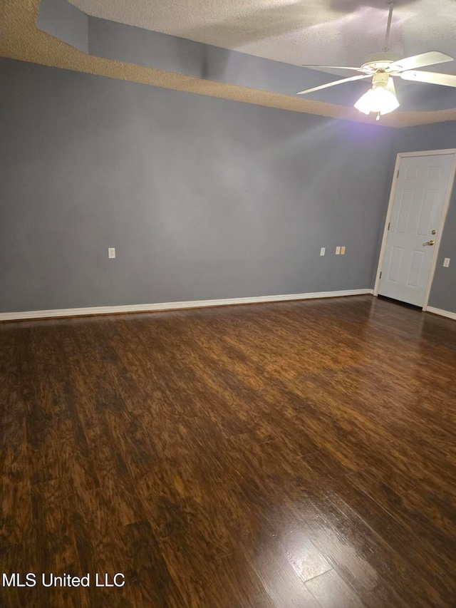 empty room featuring ceiling fan, dark hardwood / wood-style flooring, and a textured ceiling