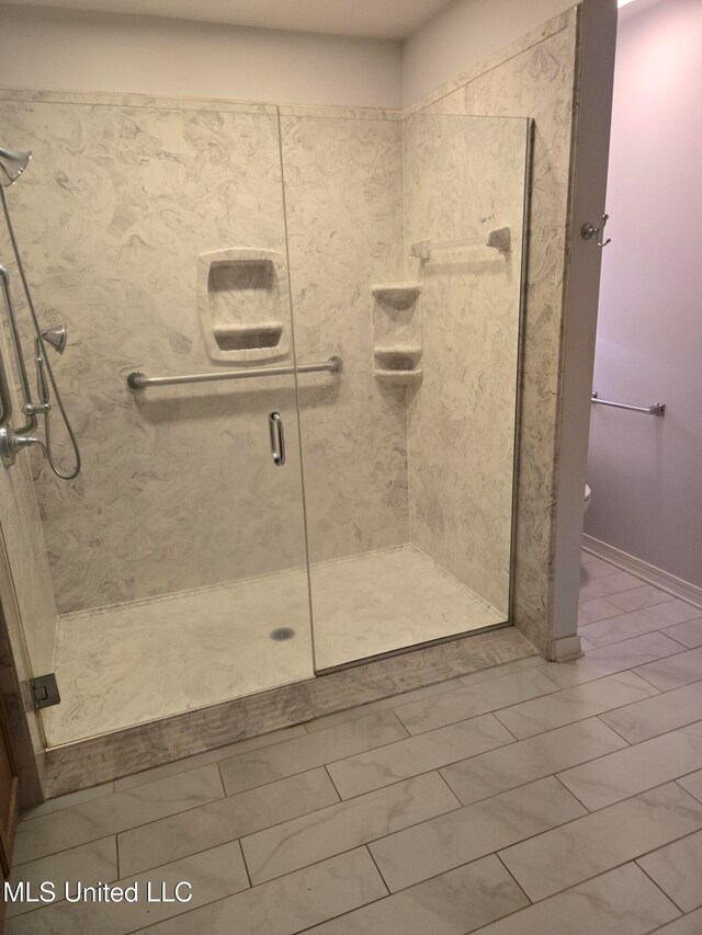 bathroom featuring tile patterned flooring and an enclosed shower