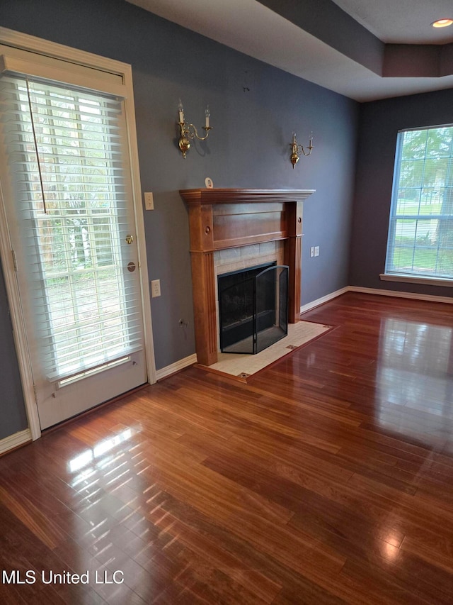 unfurnished living room featuring dark hardwood / wood-style flooring and a wealth of natural light