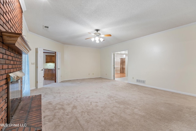 unfurnished living room featuring ceiling fan, a brick fireplace, a textured ceiling, light carpet, and ornamental molding