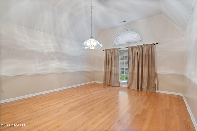 unfurnished room featuring hardwood / wood-style floors and lofted ceiling